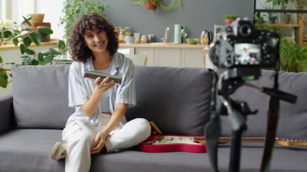 Neşeli Genç Kızı Evdeki Kanepede Oturuyor Tripodda Dijital Kamerayla Müzik — Stok video