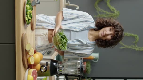 Pionowe Ujęcie Dopasowanej Blogerki Dziewczyny Stojącej Kuchni Opowiadającej Świeżych Warzywach — Wideo stockowe
