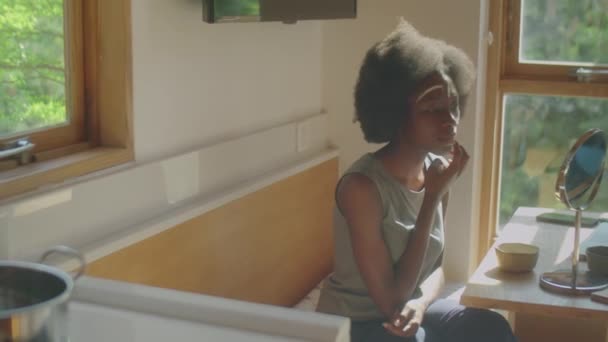 Νεαρή Αφρο Αμερικανίδα Που Εφαρμόζει Μάσκα Στο Δέρμα Του Προσώπου — Αρχείο Βίντεο
