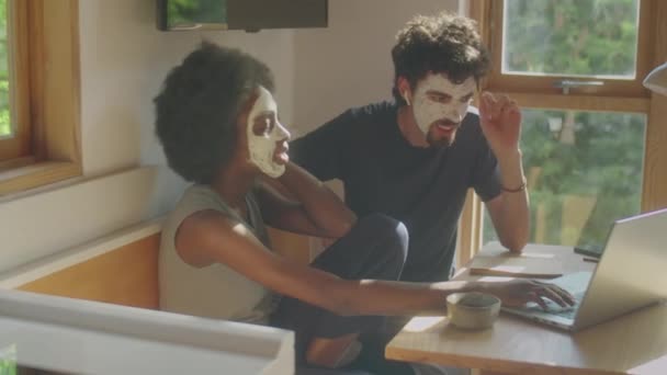 Mladí Multietnický Pár Hliněnými Maskami Tvářích Procházení Internetu Notebooku Chatování — Stock video
