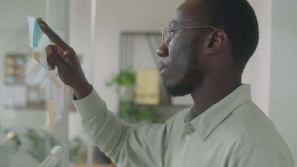 Közepes Közelkép Afro Amerikai Üzletemberről Aki Ragacsos Jegyzeteket Ragaszt Üvegfalra — Stock videók
