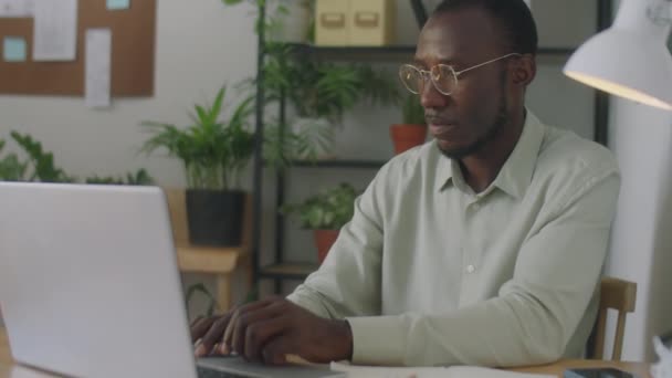 中慢速拍摄的非裔美国商人在办公室的笔记本电脑上工作的照片 — 图库视频影像