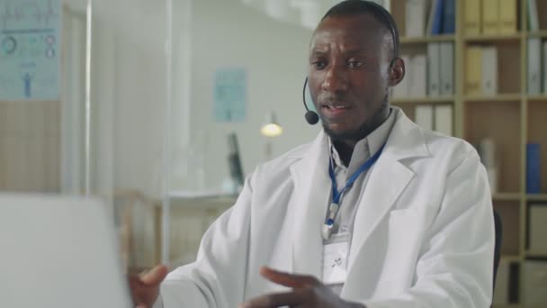 Selective Focus Shot Black Male Doctor Headset White Coat Sitting — Stock Video