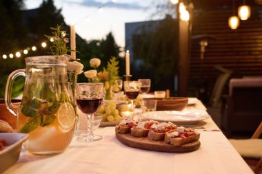 Masanın, ferahlatıcı limonata, kırmızı ev yapımı şarap ve ahşap tahtada iştah açıcı sandviçlerle servis edilen kısmına odaklan.
