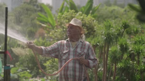 Plan Long Moyen Pépiniériste Senior Arrosant Les Plantes Avec Tuyau — Video