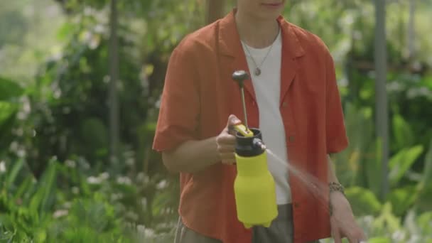 Mulher Nova Usando Garrafa Com Pulverizador Enquanto Pulveriza Plantas Com — Vídeo de Stock