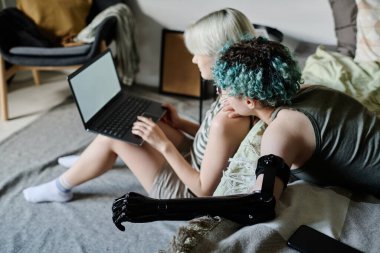 Evde dizüstü bilgisayardan film izleyen kız arkadaşların yüksek açılı görüntüsü