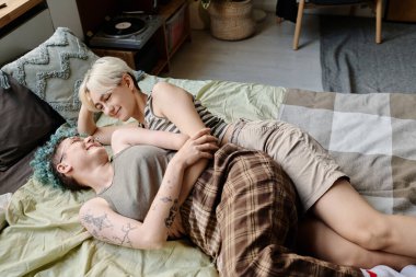 Kızların evde boş vakit geçirmesi, yatakta uzanmaları ve birlikte vakit geçirmelerinin yüksek açılı görüntüsü