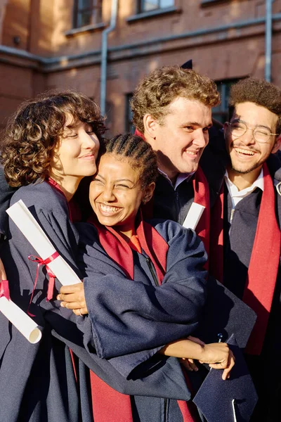 Birbirini Kucaklayan Mutlu Öğrencilerin Dikey Görüntüsü Üniversiteden Mezun Oluyorlar — Stok fotoğraf