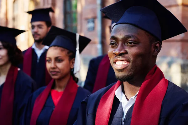 Afro Americano Feliz Estudante Roupão Sorrindo Enquanto Ouve Discurso Palestrante — Fotografia de Stock