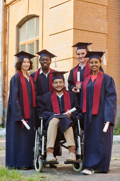 Imagem Vertical Estudantes Graduados Roupões Sorrindo Para Câmera Enquanto Estão — Fotografia de Stock