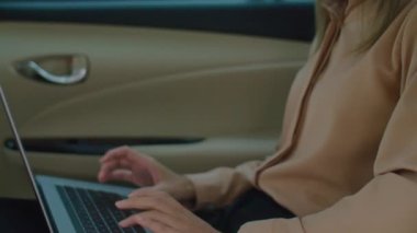 Asyalı işadamının taksinin arka koltuğunda otururken ve internette çalışırken dizüstü bilgisayarda yazarken görüntüsünü kaldır.