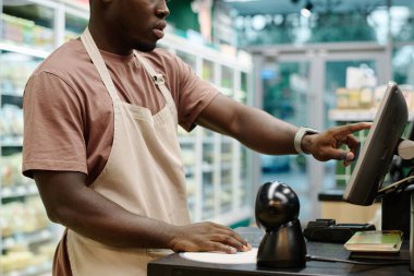 Afrikalı Amerikalı kasiyer süpermarkette bilgisayarla çalışıyor.
