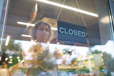 Satıcı kadın dükkânı kapatmak için kapıya yazı astı.