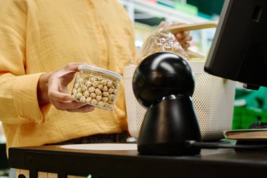 Müşteri kasanın yanında duruyor ve ürünleri süpermarkette kendisi tarıyor.