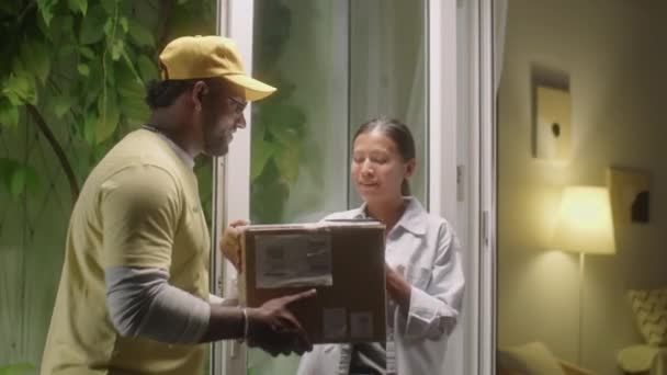 Азиатка Открывает Дверь Забирает Посылку Курьера Подписывает Документ Доставке Получении — стоковое видео