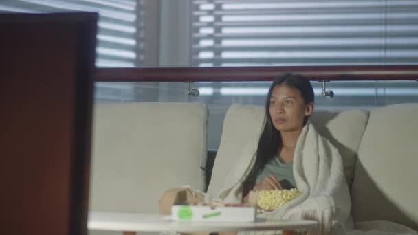 Asian Woman Sitting Sofa Blanket Shoulders Eating Popcorn Watching While — Stock Video