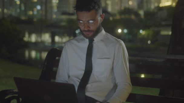 셔츠와 벤치에 앉아있는 노트북에서 온라인으로 넥타이에 비즈니스맨의 — 비디오