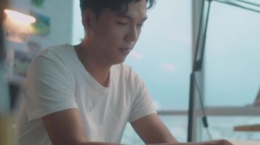 Profesyonel Asyalı ressamın, resim stüdyosundaki masasında mum boya kalemleriyle resim yaptığı orta boy yakın plan bir fotoğraf.