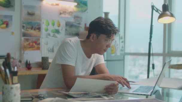 Genç Asyalı Ressamın Dizüstü Bilgisayar Kullanırken Yaratıcı Stüdyoda Çalışırken Fotoğraflara — Stok video