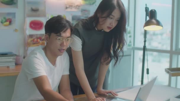 Medelhög Bild Unga Asiatiska Kollegor Diskuterar Pappersritning Och Använda Laptop — Stockvideo