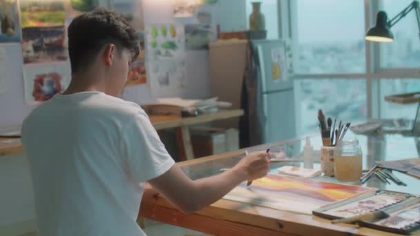 Imagem Pintura Artista Masculino Papel Com Escova Enquanto Trabalhava Mesa — Vídeo de Stock