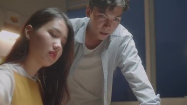 Resim dersi alırken, Asyalı genç bir kadının erkek öğretmenin kontrolü altında resim çizerken yakın plan çekimini yapın.