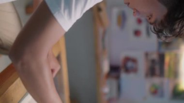 Asyalı erkek ressamın, yaratıcı stüdyoda suluboya ve boya fırçasıyla resim çizdiği dikey yakın çekim.