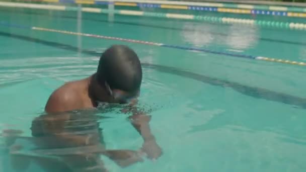 夏の屋外プールでゴーグルとキャップのアフリカ系アメリカ人男性選手のスローモーションショット — ストック動画
