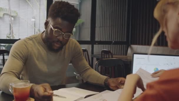 Через Плече Чорношкірого Чоловіка Обговорюється Бізнес План Паперах Ноутбуках Жінкою — стокове відео