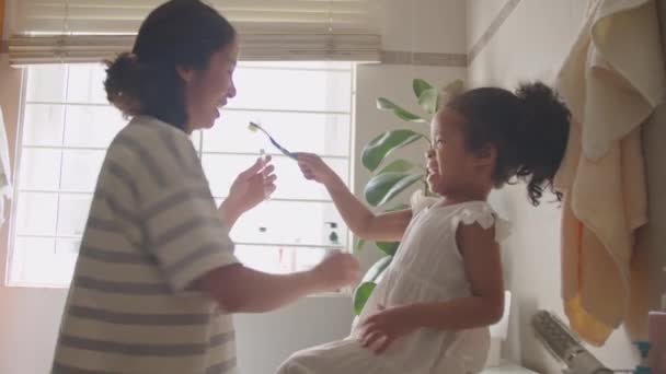Χαριτωμένο Ασιατικό Κοριτσάκι Βοηθώντας Μαμά Βούρτσισμα Των Δοντιών Και Παίζοντας — Αρχείο Βίντεο