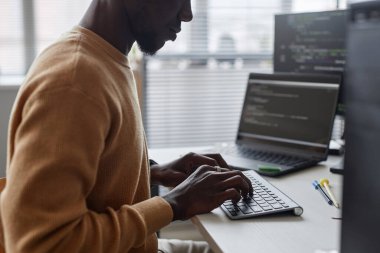IT ofisinde otururken program için kod yazan Afrikalı Amerikalı programcı