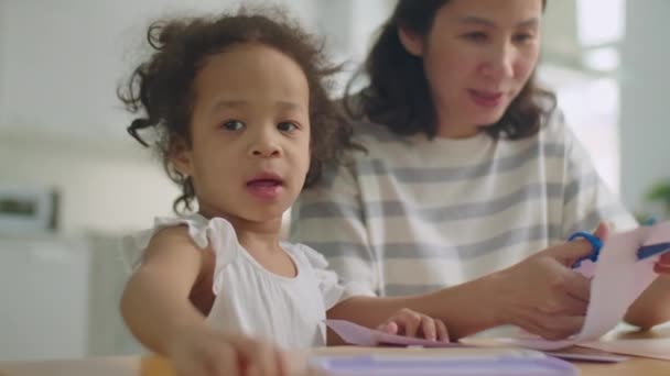 Маленькая Азиатская Девочка Рисует Карандашом Мать Режет Бумагу Ножницами Делая — стоковое видео
