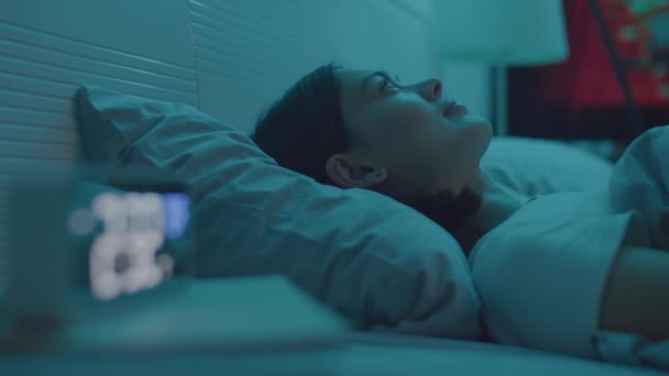 年轻女子躺在黑暗的卧室里 晚上睡眠不足时 在数字时钟上看时间 这是一张精准的照片 — 图库视频影像