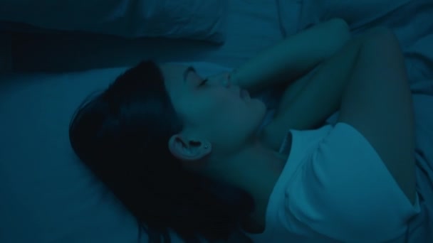 夜间躺在黑暗房间里的年轻女子侧卧在床上的自上而下的镜头 — 图库视频影像