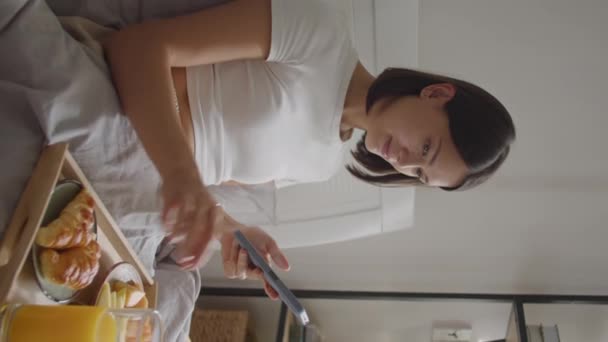 Tiro Vertical Mujer Joven Desayunando Cama Bebiendo Jugo Naranja Mensajes — Vídeos de Stock