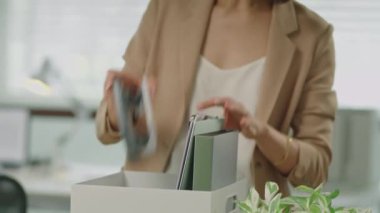 Kovulan iş kadını, son iş gününde ofisten çıkarken eşyalarını kutuya koyar.