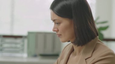 İş kadınının dokunmatik dokunmatik kağıt kullanarak ve ofis masasında çalışırken dizüstü bilgisayarını çekerken yakın plan çekimini yap.