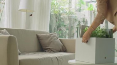 İşsiz bir kadın eve ofis eşyalarıyla kutu getiriyor, kanepeye oturuyor, kovulduktan sonra stresli ve üzgün hissediyor.