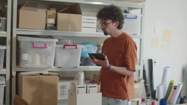 Genç Adam Rafları Kontrol Ediyor Teslimat Bürosunda Envanter Sırasında Dizüstü — Stok video