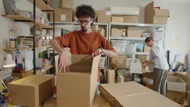Joven Usando Cinta Adhesiva Haciendo Caja Cartón Para Enviar Mientras — Vídeos de Stock