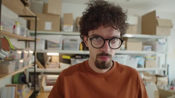 Teslimat Şirketinin Ofisinde Kameraya Poz Veren Gözlüklü Sıradan Tişörtlü Genç — Stok video
