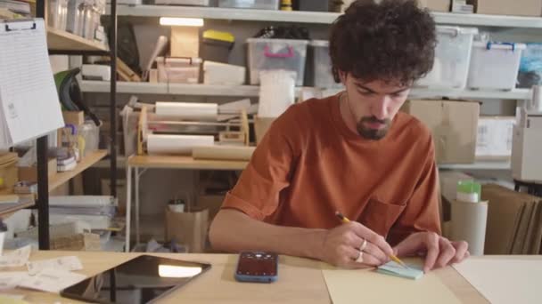 Genç Bir Adamın Teslimat Bürosunda Masa Başında Oturup Yapışkan Notlar — Stok video