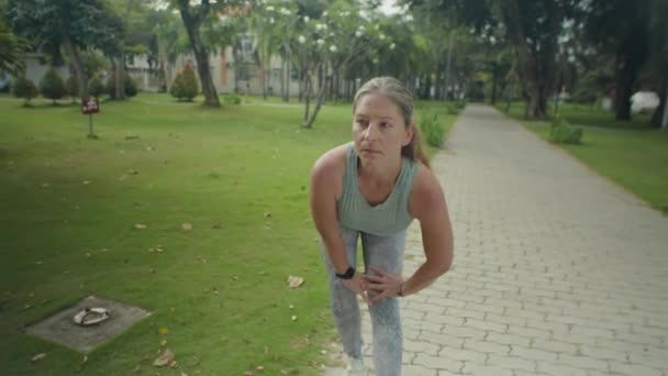 Νεαρή Αθλητική Γυναίκα Αθλητικά Ρούχα Έλεγχο Smartwatch Τεντώνοντας Πόδια Και — Αρχείο Βίντεο