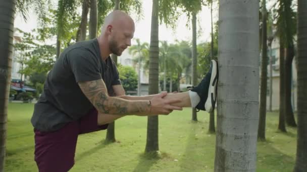 Spor Kıyafetli Genç Adam Antrenman Için Hazırlanırken Palmiye Ağacının Yanında — Stok video