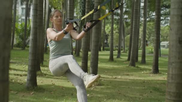 Spor Kıyafetli Bir Kadının Parkta Antrenman Yaparken Askılarla Tek Bacakla — Stok video