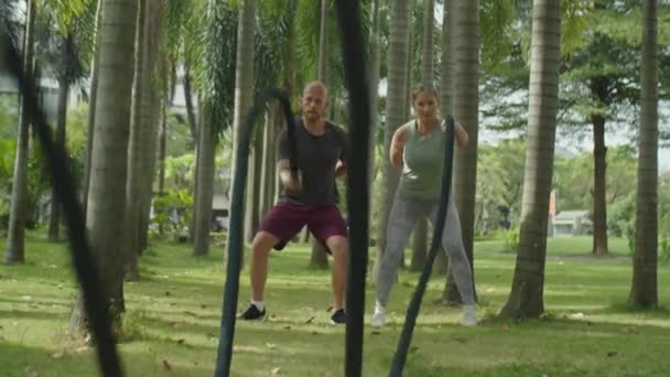 Spor Yapan Çiftin Tek Koluyla Savaş Halatı Sallarken Yaz Günü — Stok video