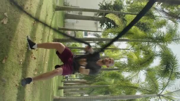 夏季户外运动训练中 运动员在公园里交替进行战斗绳纵横拍 — 图库视频影像
