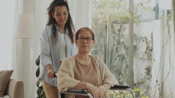 Mulher Asiática Sênior Alegre Cadeira Rodas Conversando Com Cuidador Feminino — Vídeo de Stock