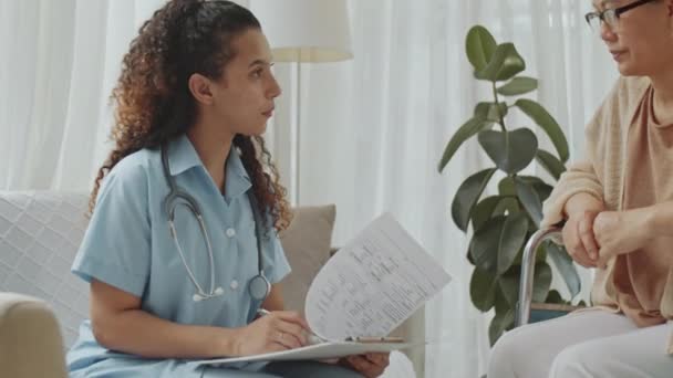 Пригнічений Знімок Молодої Жінки Лікаря Медичній Формі Роблячи Нотатки Обговорюючи — стокове відео